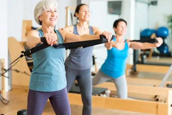 Toning Arms After 60: Empowering Womens Fitness Through Effective Weight Training 2 older woman doing weight training Sudbury and resistance in the gym to tone upper arms