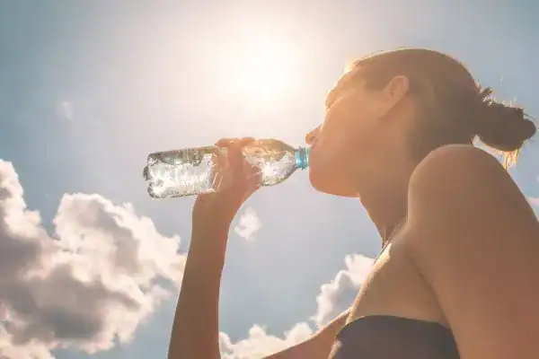 Hydration: The Secret Ingredient for a Toned Stomach and Enhanced Fitness 3 Image of woman drinking water to hydrate Sudbury after run.