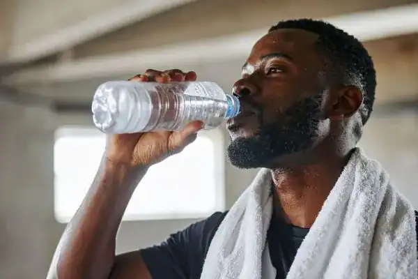 Hydration: The Secret Ingredient for a Toned Stomach and Enhanced Fitness 1 Image of man drinking water to improve hydration Sudbury after work out.